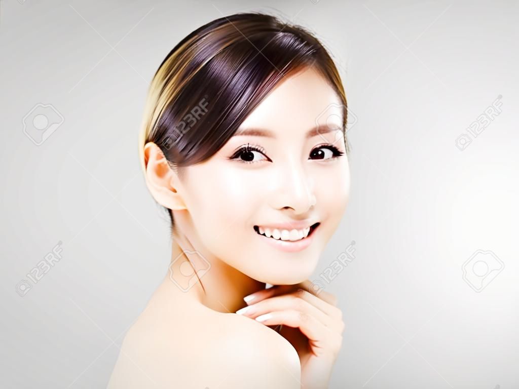 jonge glimlachende vrouw gezicht met grijze achtergrond
