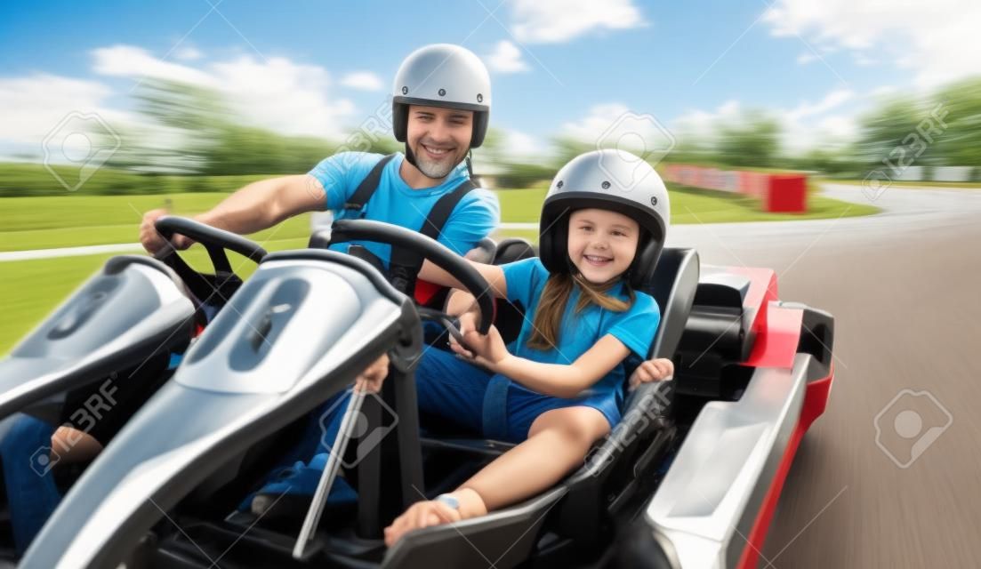 father and daughter driving go kart on the track