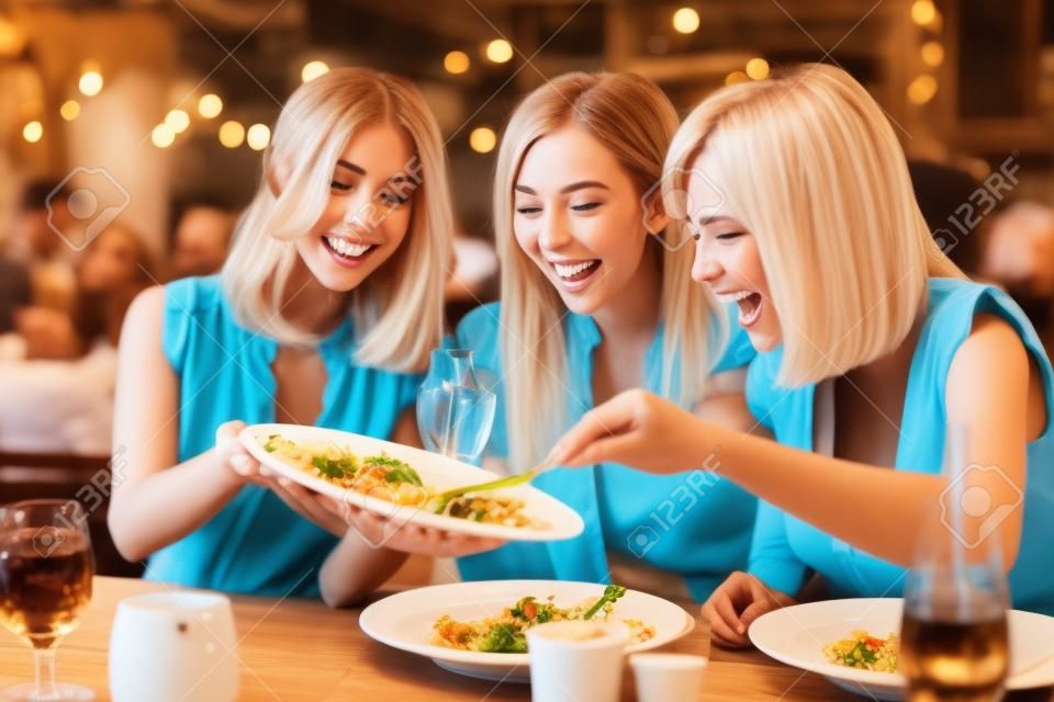 Grupo de amigos felices cenando en el restaurante