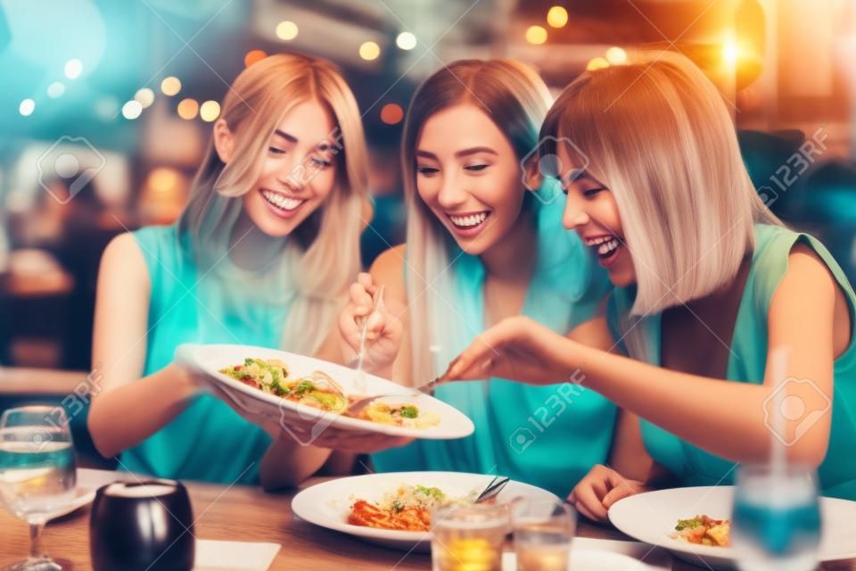 Gruppo di amici felici che cenano al ristorante
