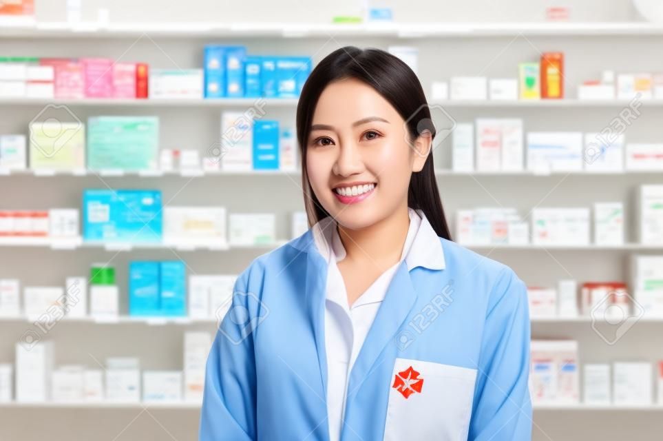 A portrait of asian woman pharmacist wearing lab coat in a modern pharmacy drugstore.