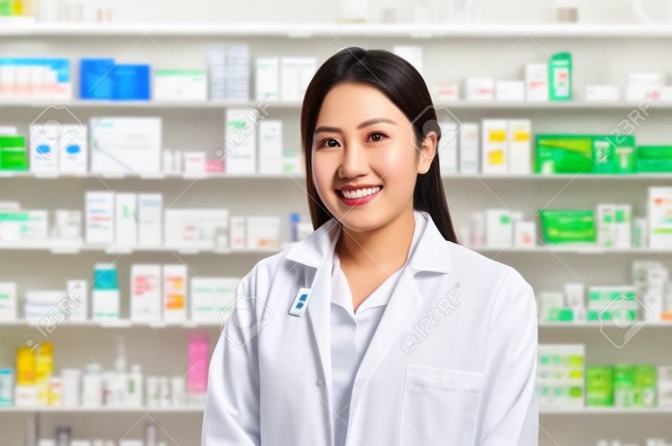 A portrait of asian woman pharmacist wearing lab coat in a modern pharmacy drugstore.