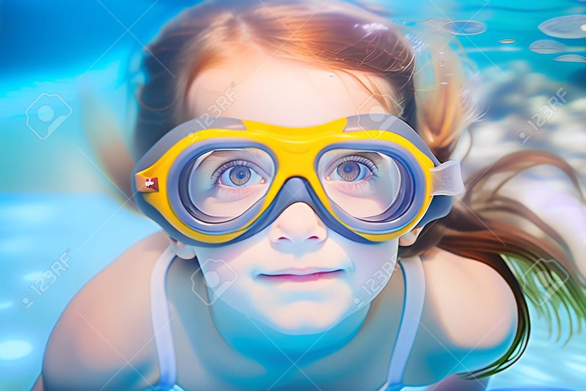 les enfants sous-marins de natation fille avec des lunettes et des gestes drôles
