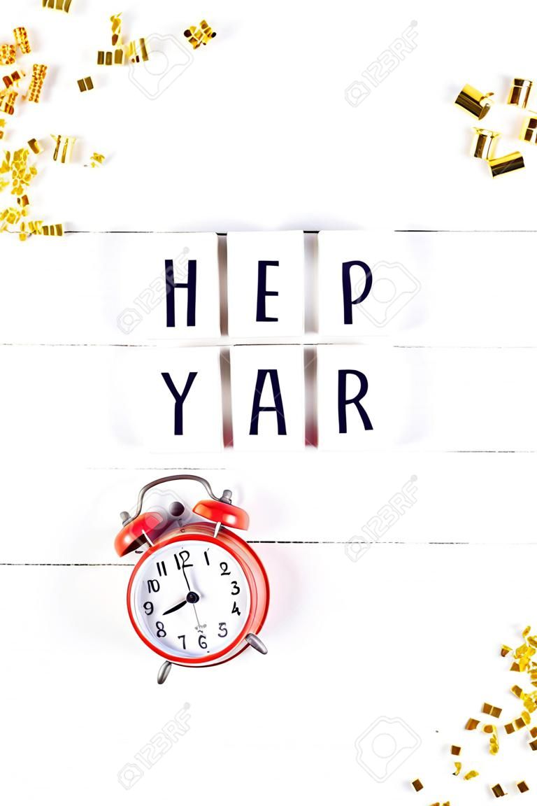 New Year or Christmas pattern flat lay top view red alarm clock twelve midnight Xmas holiday celebration white wooden golden sparkles confetti background. Template for your text design 2019