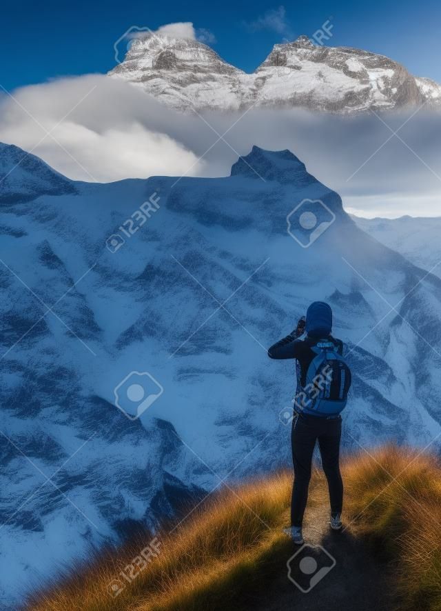 Az utazó sikoltozik a hegycsúcsok hátterében, a svájci Engelberg üdülőhelyen