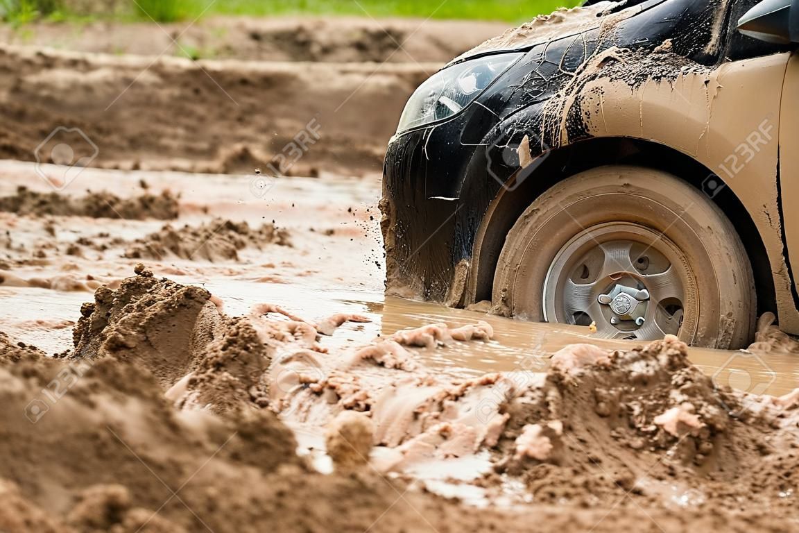 泥の中で立ち往生している黒い車を閉じます。泥から落ちることができません。
