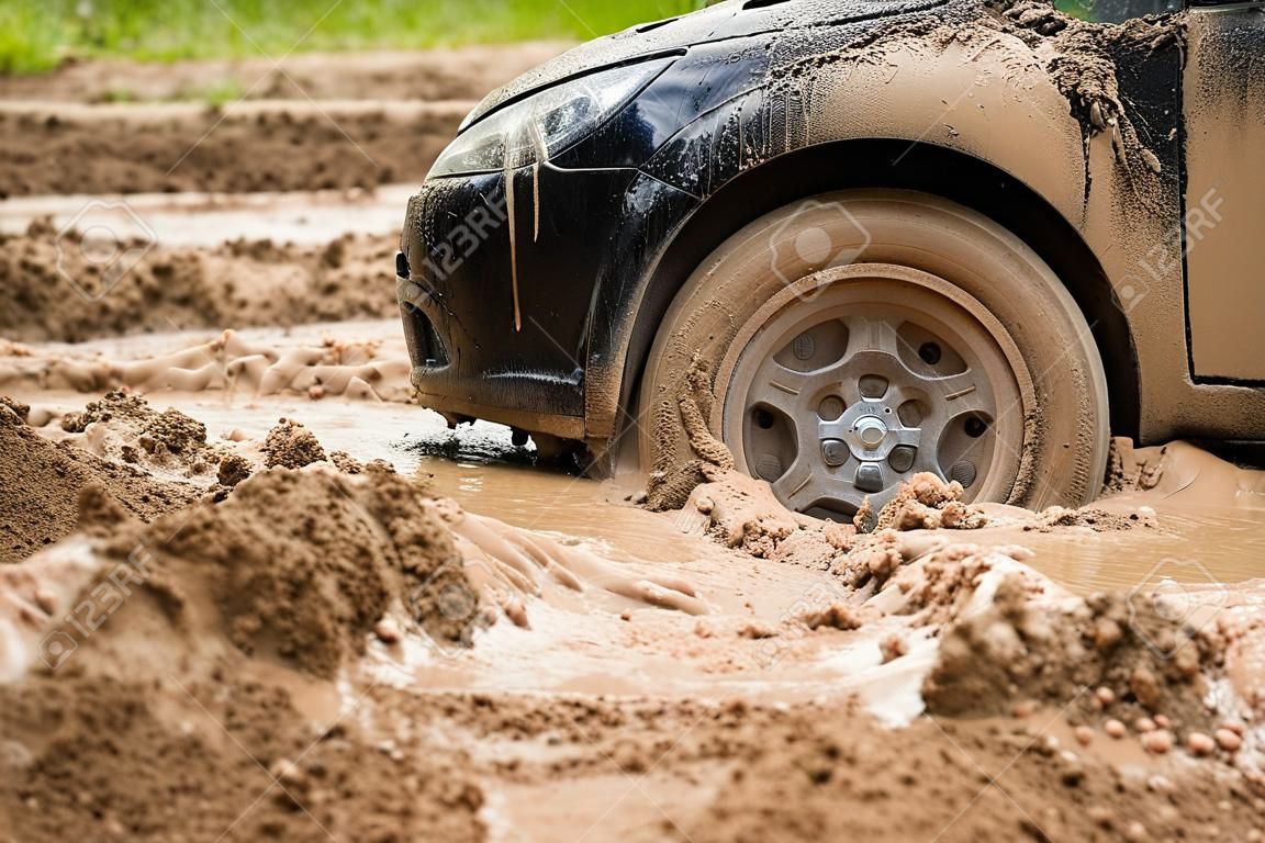 Chiudi la macchina nera bloccata nel fango. Non può cadere fuori dal fango