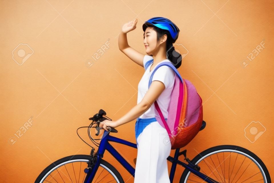 Bella donna asiatica Sta pedalando al sole.