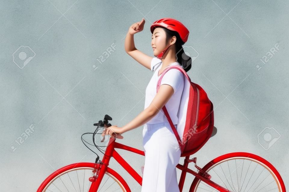 Hermosa mujer asiática Ella está en bicicleta bajo el sol.