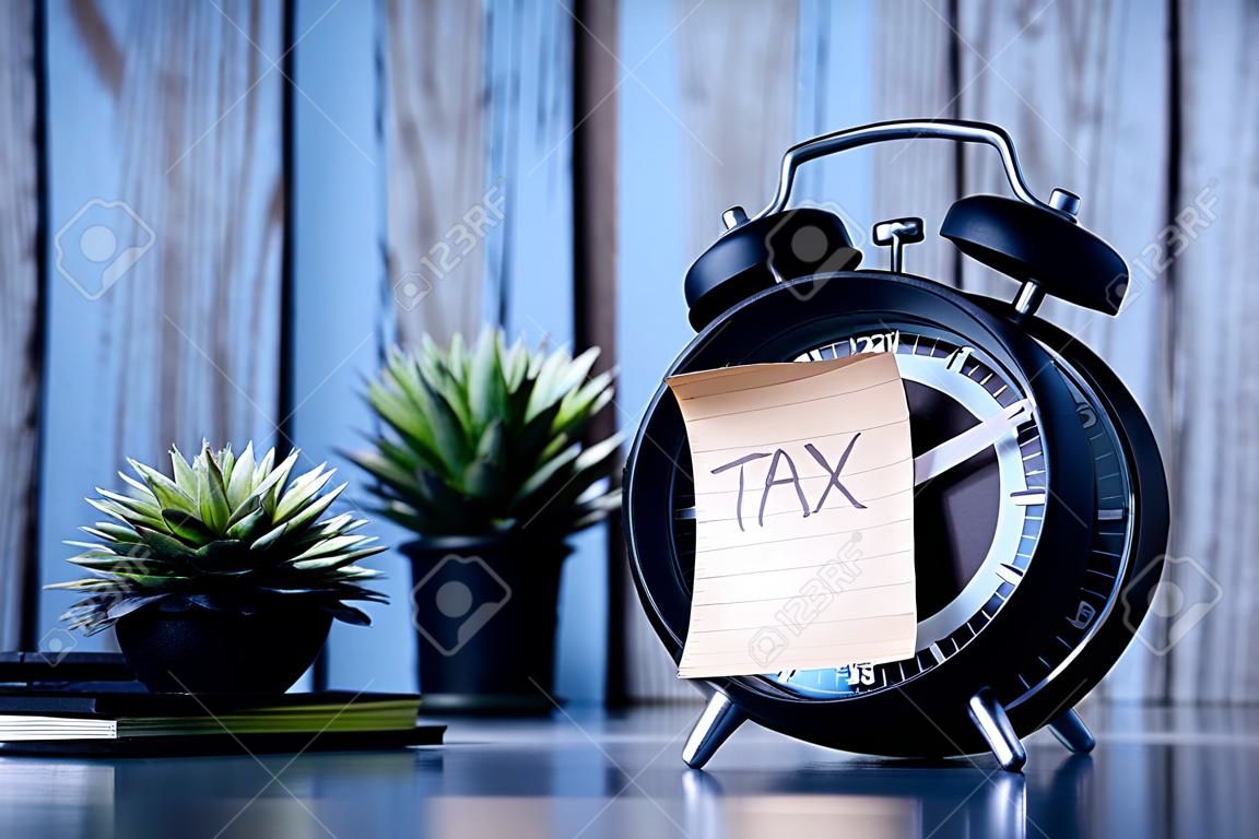 Tax Text on Adhesive Note on Alarm Clock.