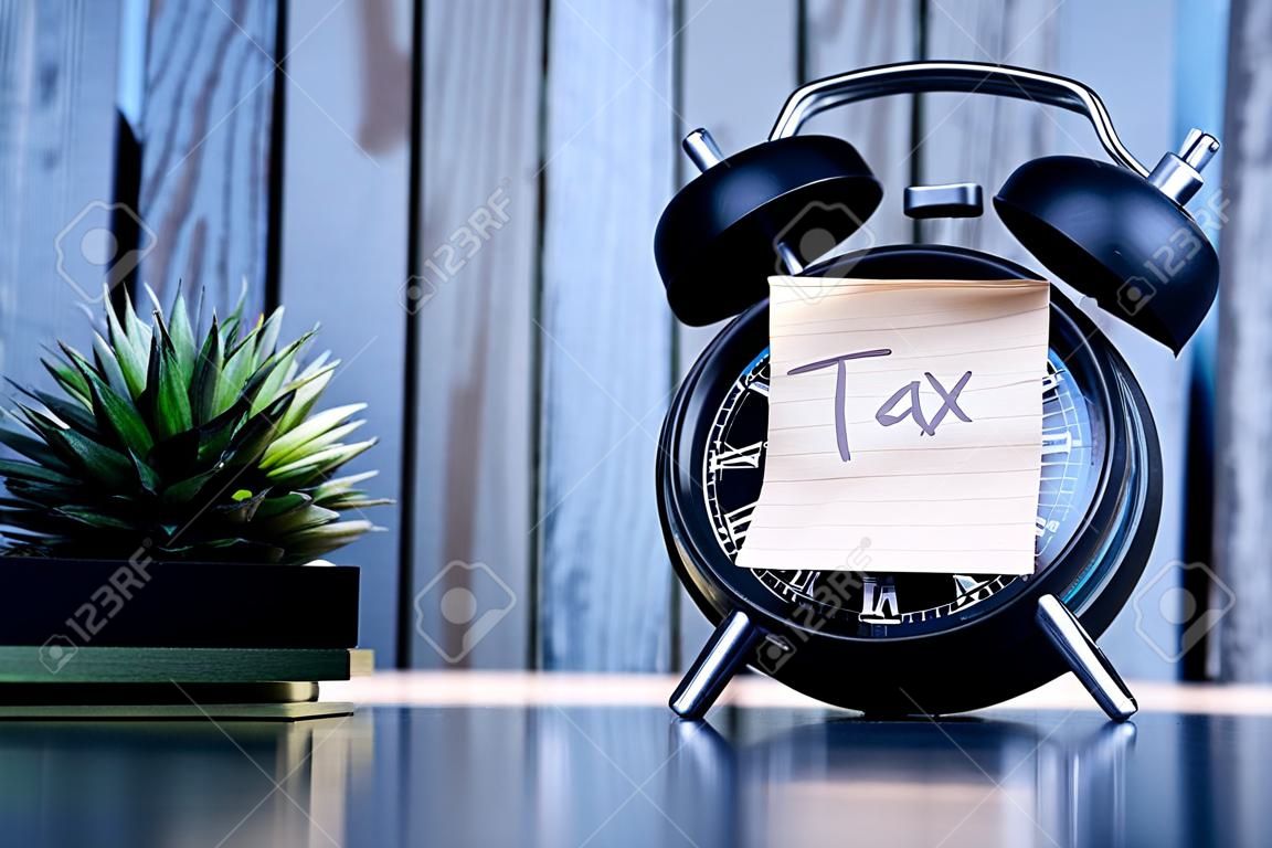 Tax Text on Adhesive Note on Alarm Clock.