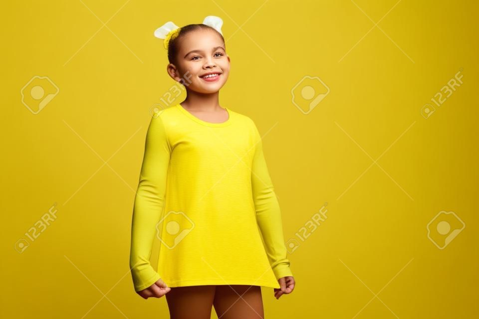 La Niña En Camiseta Amarilla Está Sonriendo Imagen de archivo