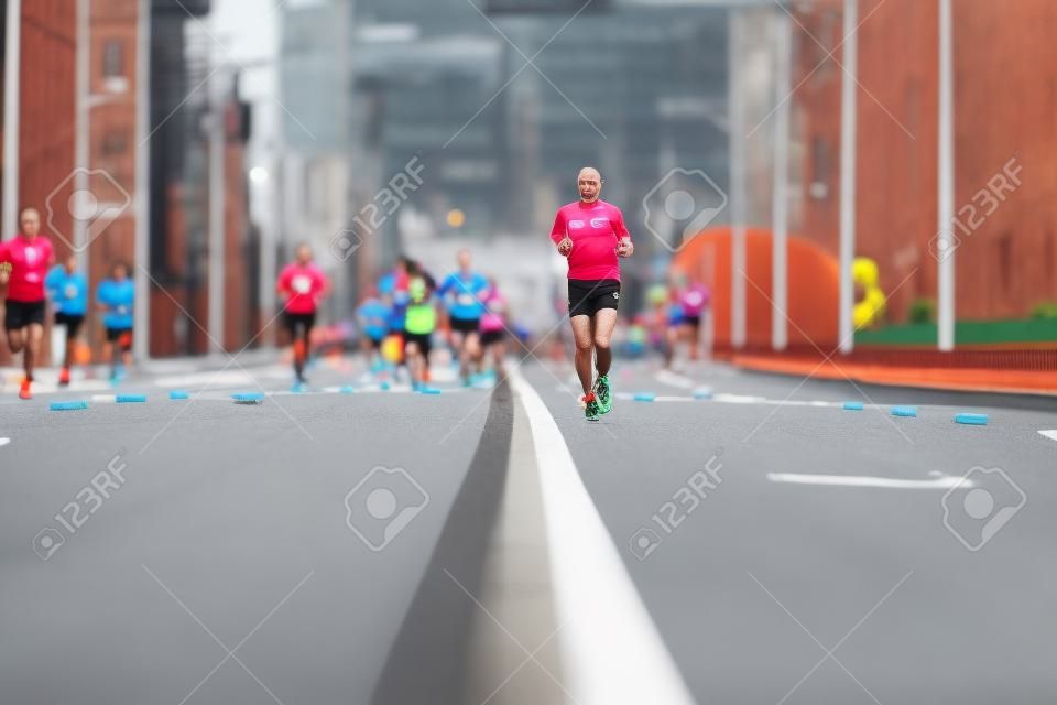 Marathon runners on city road. Running competition, copy space. Street sprinting outdoors. Healthy sport event.