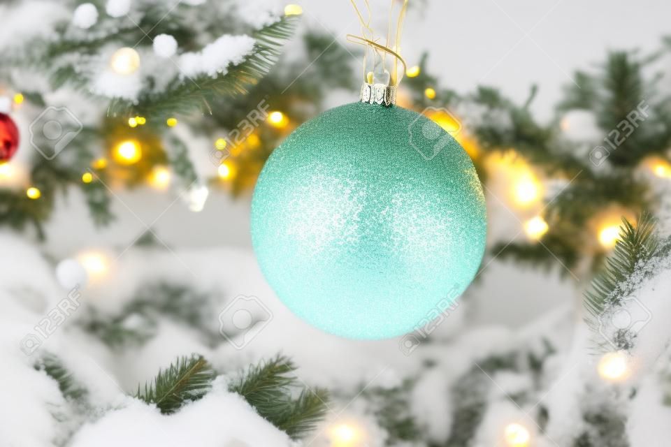 Kerstboom decoraties bedekt sneeuw, outdoor xmas boom met decoratieve gele bollen