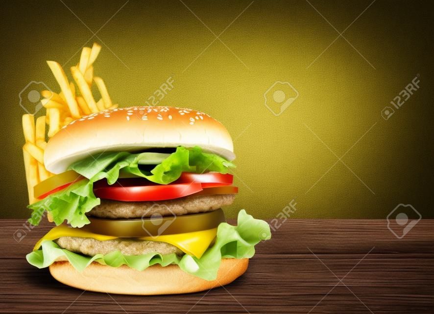 Doppio hamburger fresco e patatine fritte su sfondo verde della natura. Copia spazio
