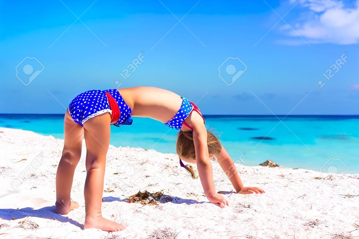 Adorable little sporty girl on white tropical beach