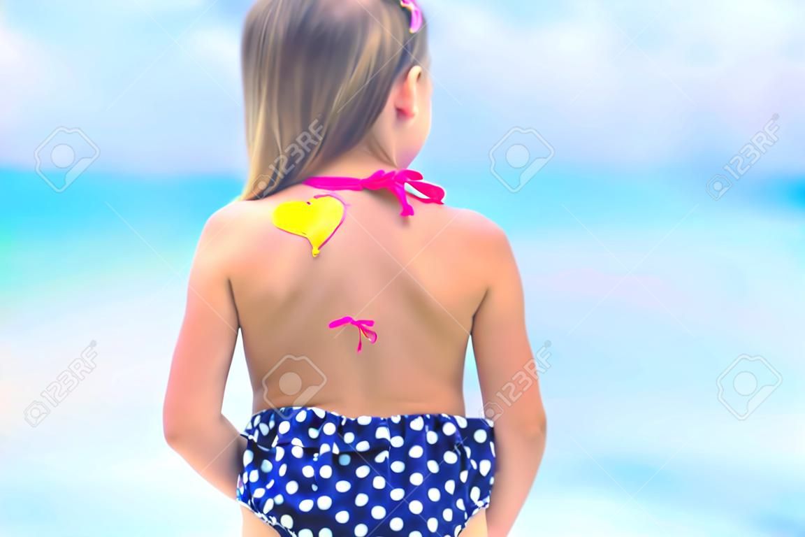 Close up heart painted by sun cream on kid shoulder