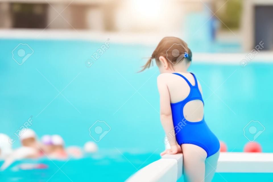 Kleine actieve schattige meisje in buiten zwembad klaar om te zwemmen