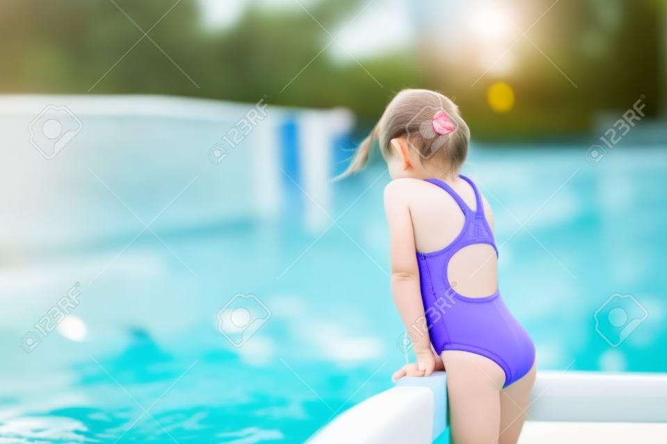 Kleine actieve schattige meisje in buiten zwembad klaar om te zwemmen