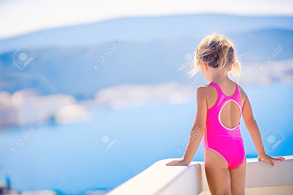 Mała aktywna urocza dziewczyna w odkrytym basenie gotowa do pływania