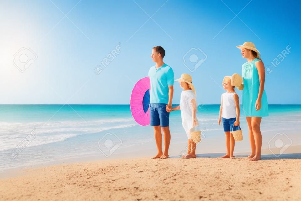 Familie van vier op een tropisch strand