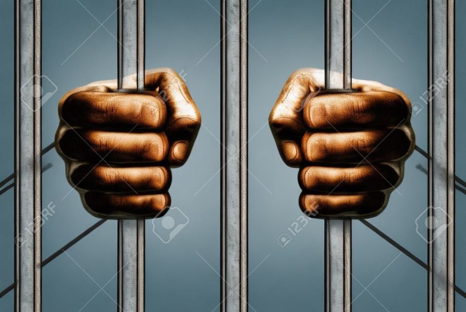 刑務所の刑務所バーの背後にある刑務所棒の手を握って手手します。