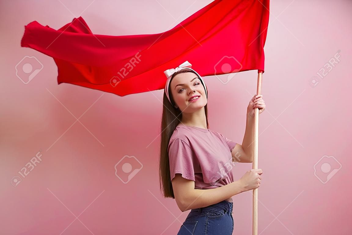 ativista e revolucionária, jovem mulher com uma bandeira vermelha em um fundo rosa. Feminismo e a luta por direitos, conceito
