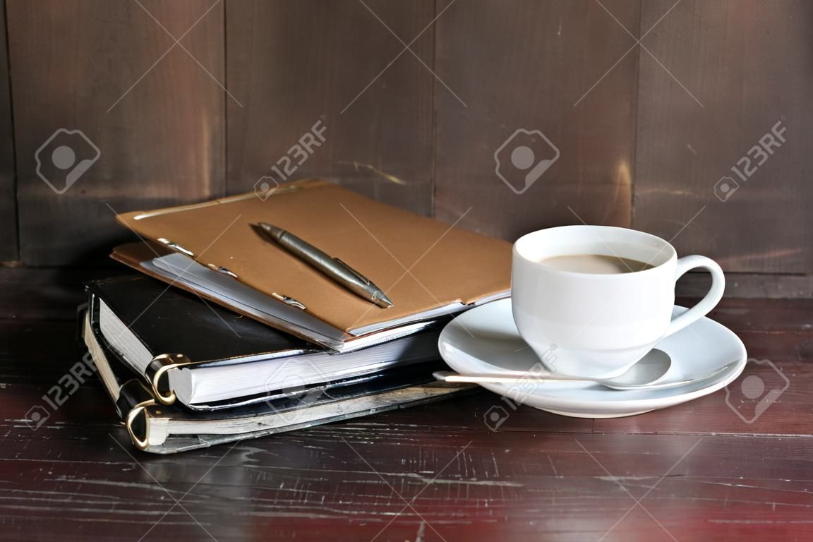 todavía la vida con el café y el bloc de notas en la mesa de madera