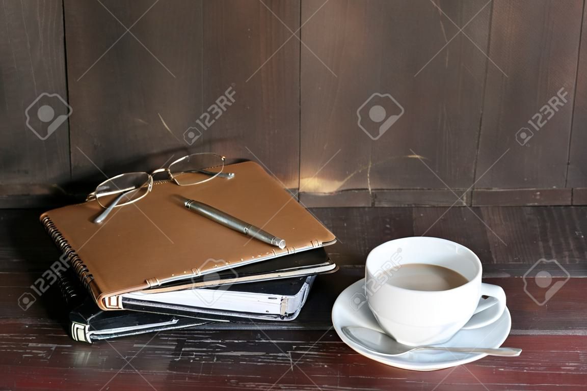 todavía la vida con el café y el bloc de notas en la mesa de madera