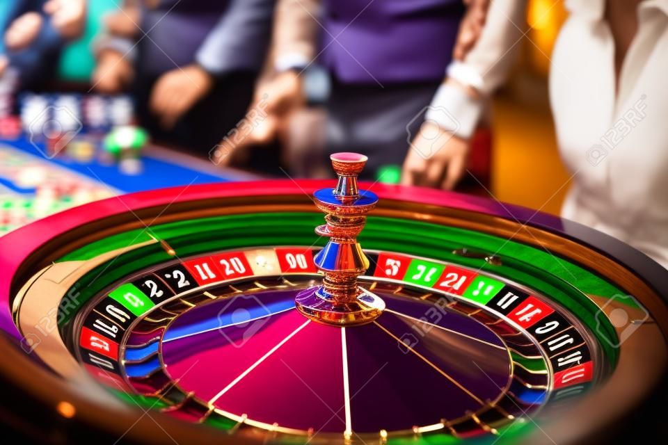 Uma imagem vibrante de close-up de mesa de cassino multicolorida com roleta em movimento, com fichas de cassino. a mão de croupier, mone e um grupo de pessoas ricas em jogos de azar no fundo