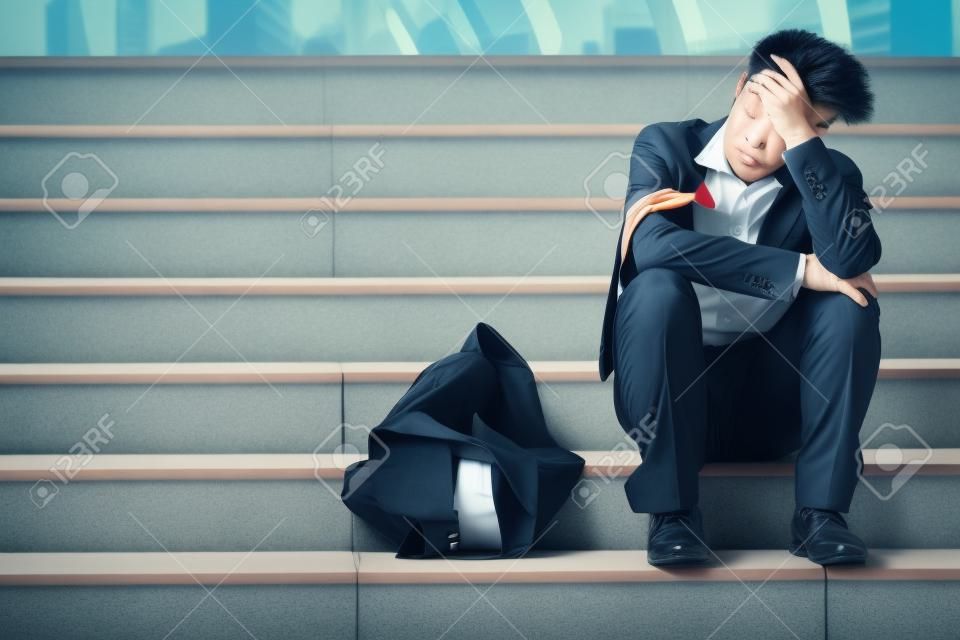 Werkloze gestresseerd jonge Aziatische zakenman in pak dekking gezicht met handen. Falen en ontslag concept.