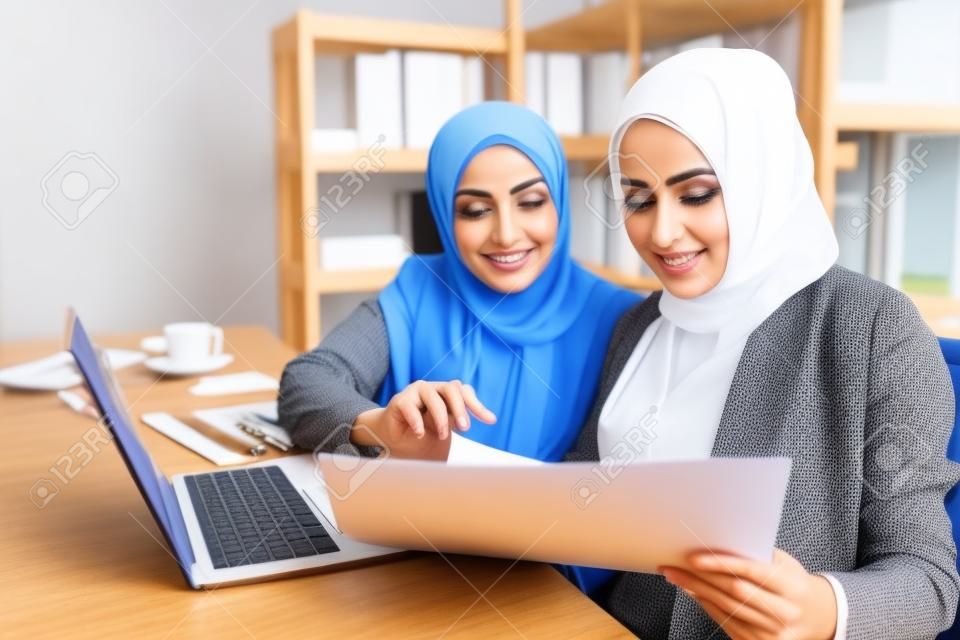 Muzułmańska biznesowa kobieta w tradycyjnej odzieży pracuje i dyskutuje na spotkaniu w biurze