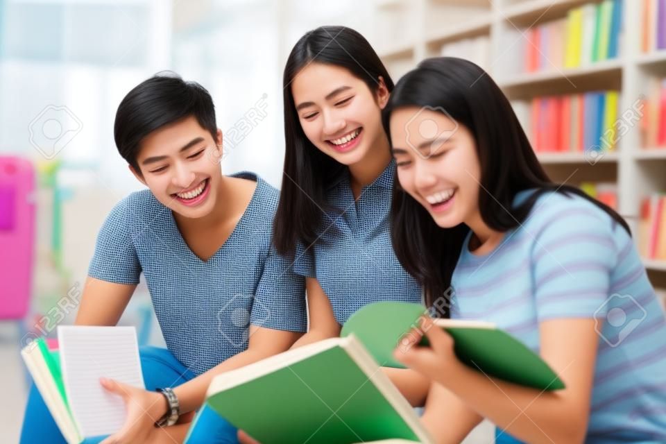 Group Asian  Students Smile and reading book and using notebook for helps to share ideas in the work and project. And also review the book before the exam