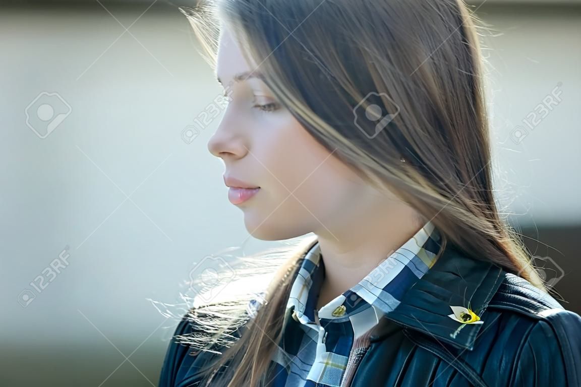Linda jovem menina closeup com rosto pensativo dia ensolarado ao ar livre