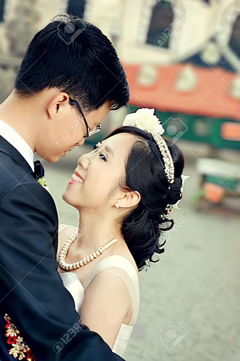 中国かわいい花嫁および新郎だけ結婚して若い新婚カップル結婚式の日に、旧市街の通り抱っこ
