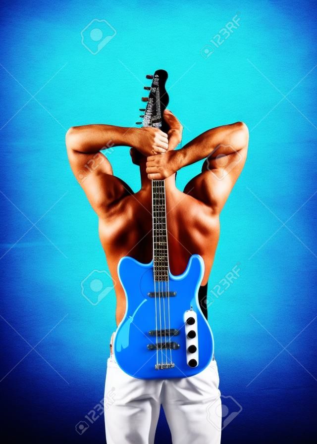 Sportsman with muscular back hold electric guitar on sunny blue sky. Music and sport concept
