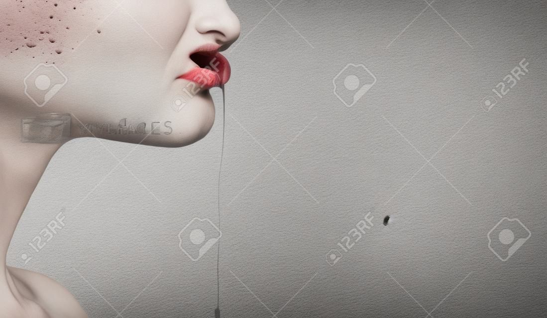 Part of female face with saliva drool from mouth lips on blurred white brick wall. Disorder, autism, madness, depression, disease concept, copy space