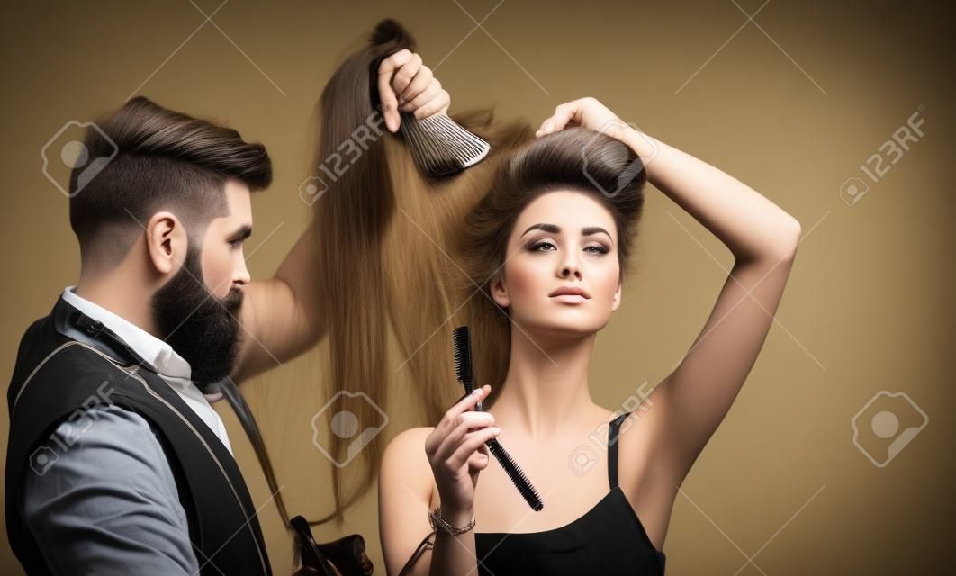 Professional hairstylist in barbershop interior. Hair Preparation is just for the dashing chap. Bearded stylish barber shop client.