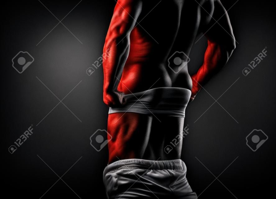 Guy. Muscular man, strong Athletic Man showing his perfect back isolated on black background