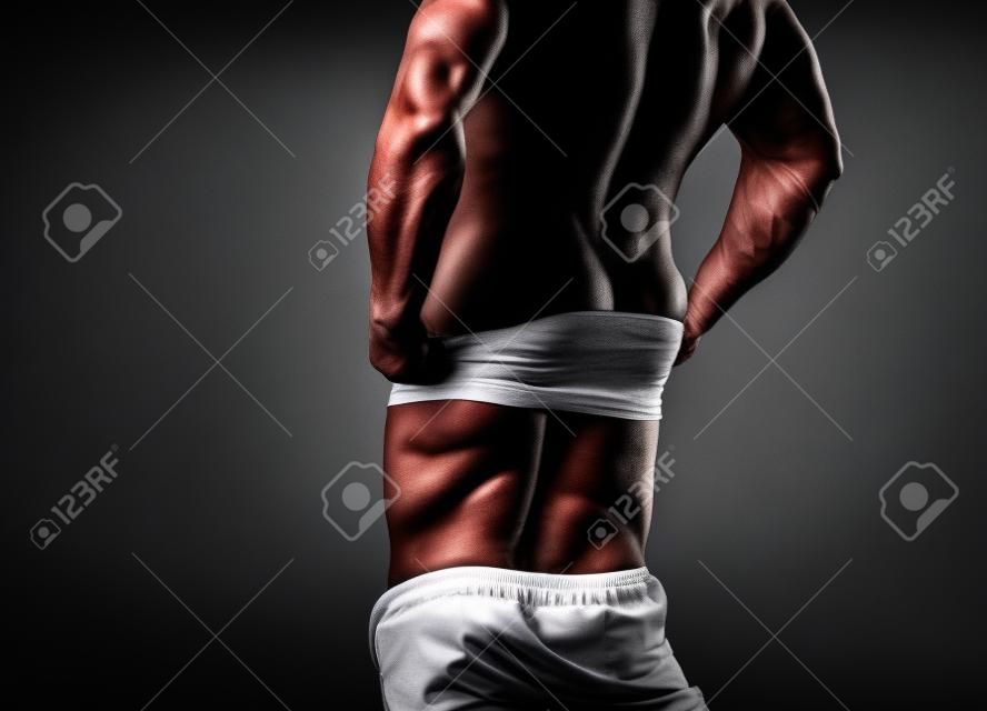 Guy. Muscular man, strong Athletic Man showing his perfect back isolated on black background