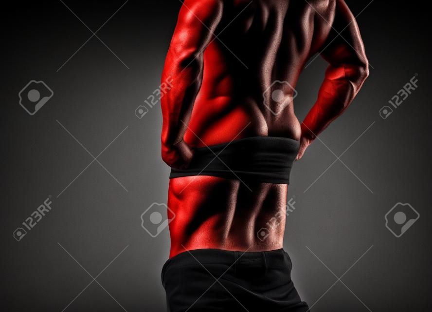 Tipo. Uomo muscoloso, forte uomo atletico che mostra la sua schiena perfetta isolata su sfondo nero