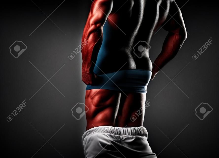 Cara. Homem musculoso, homem atlético forte que mostra suas costas perfeitas isoladas no fundo preto