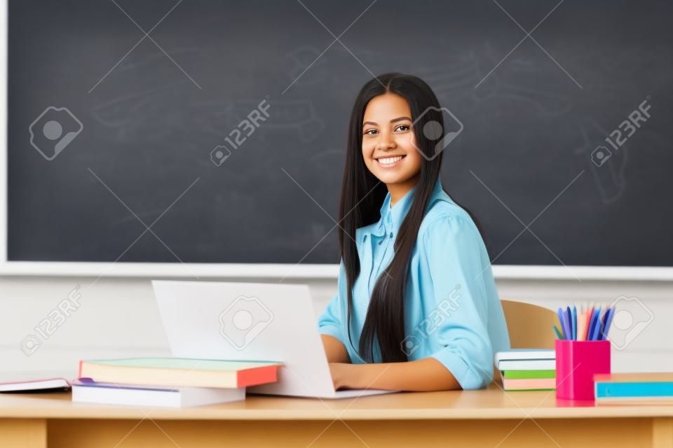 Estudante fêmea bem sucedida na sala de aula da universidade. Retrato de estudante universitário fêmea nova que estuda na sala de aula na classe com fundo do quadro-negro.