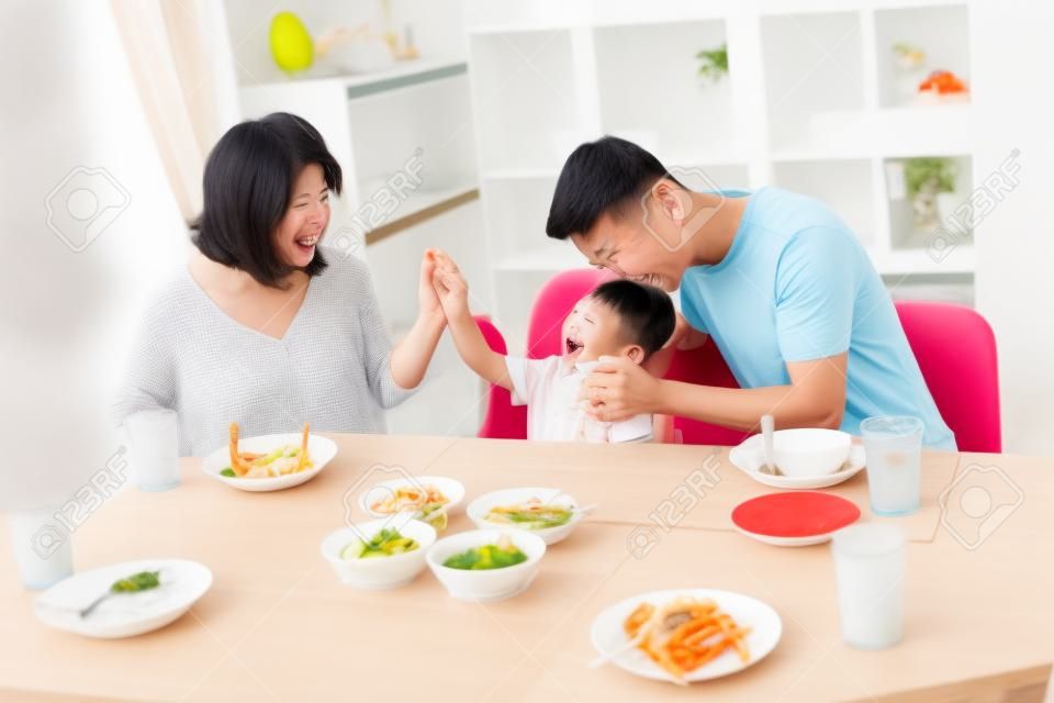 Gelukkige Aziatische familie van vader, moeder en zoon spelen en lachen tijdens het eten