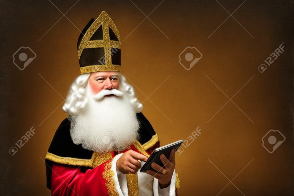 Sinterklaas kijkend op tablet. geïsoleerd op witte achtergrond. Nederlands karakter van de kerstman