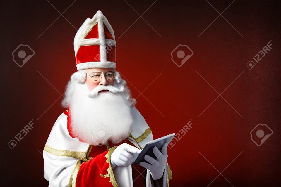 Sinterklaas kijkend op tablet. geïsoleerd op witte achtergrond. Nederlands karakter van de kerstman
