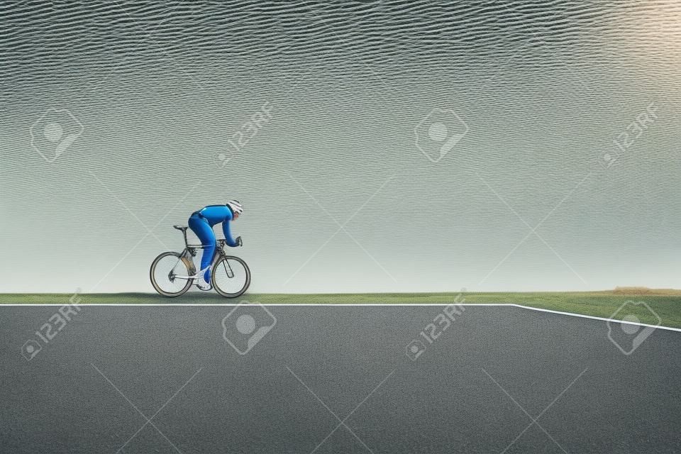 Ciclista bello in abbigliamento sportivo in bicicletta su strada