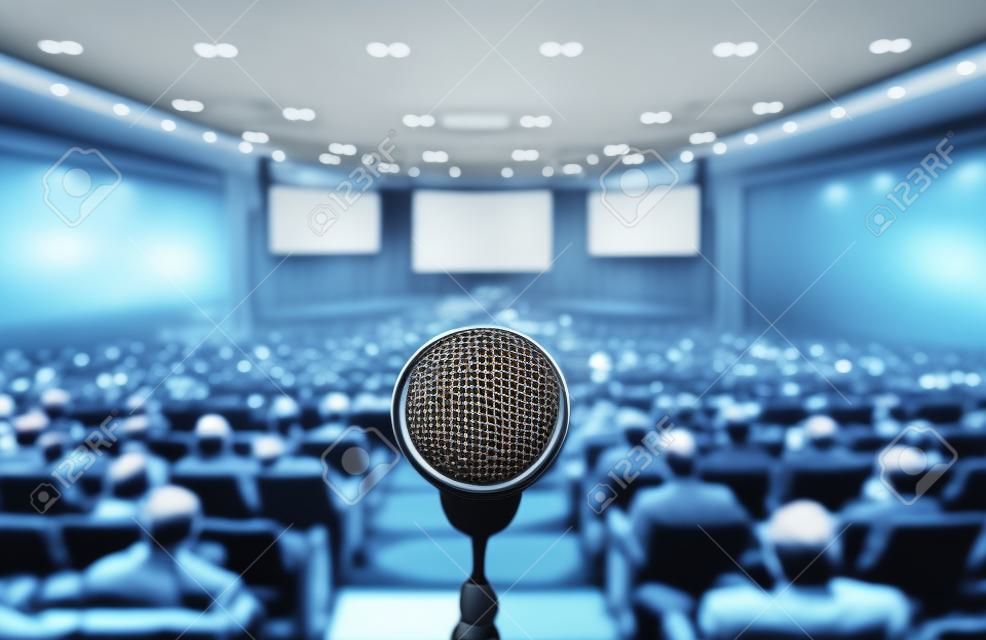 Microphone over the Abstract blurred photo of conference hall or seminar room with attendee background, Business meeting concept