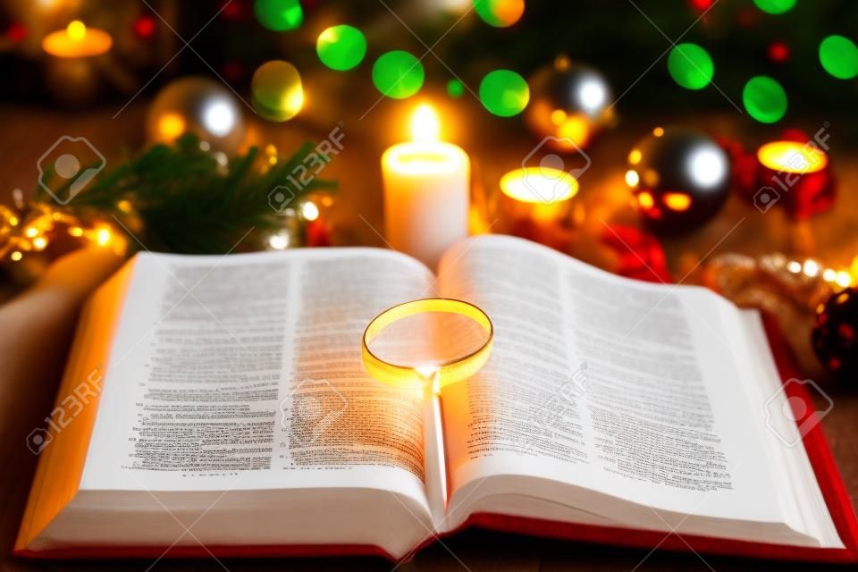 Christmas and bible with blurred candles light background
