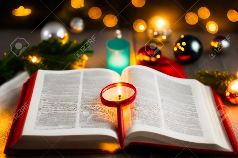 Christmas and bible with blurred candles light background